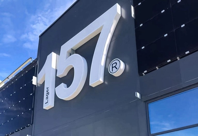 The Lager 157 store exterior, their name in raised white lettering on a dark facade under a clear sky.