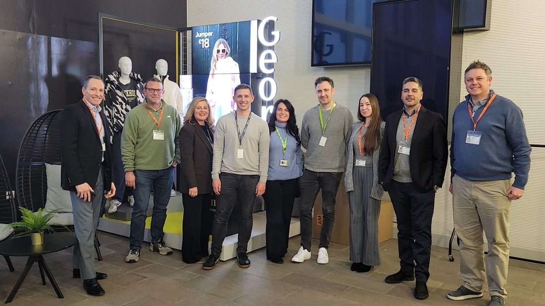 The team with a customer's team in their showroom.